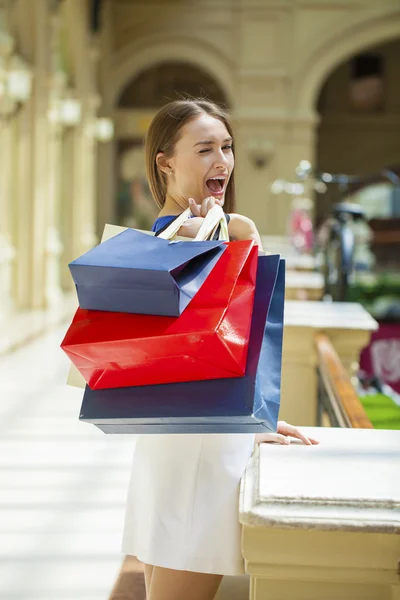 Gelukkig brunette vrouw met sommige rode boodschappentas — Stockfoto