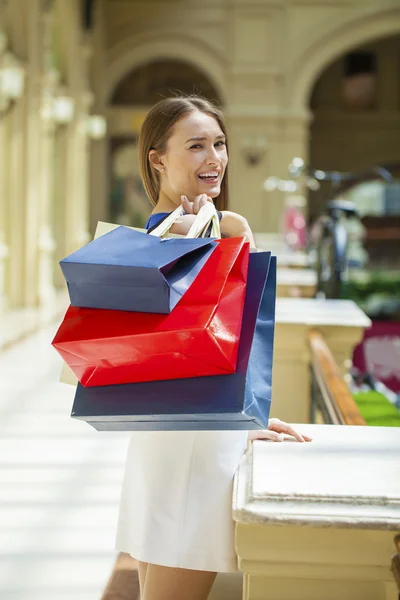 Heureuse femme brune avec un sac à provisions rouge — Photo