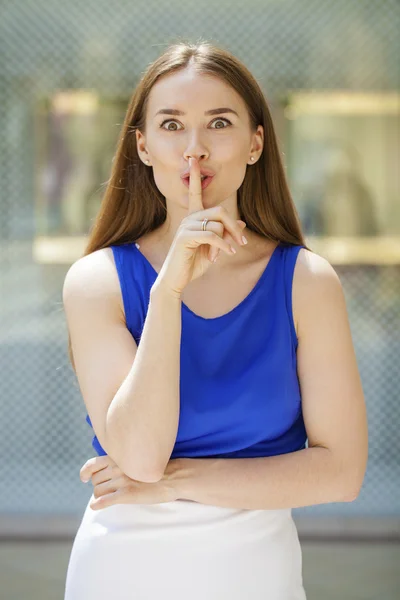 Jonge mooie brunette vrouw heeft wijsvinger lippen breng als sig — Stockfoto