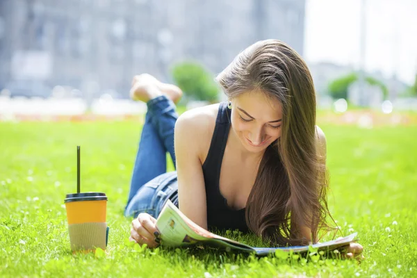 Jeune belle femme assise dans le parc d'été — Photo