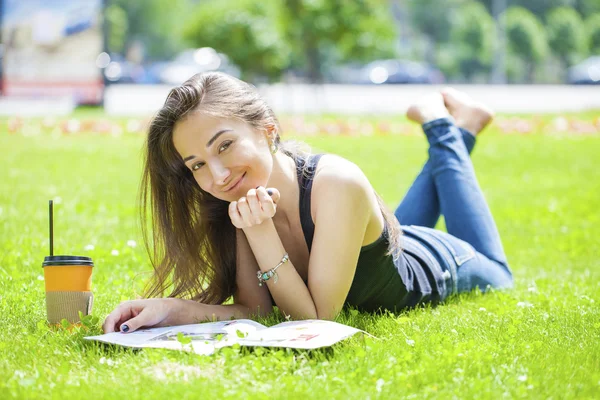 Ung vacker kvinna sitter i parken sommaren — Stockfoto