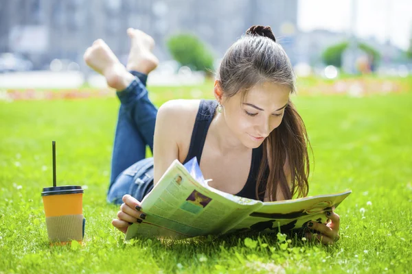 Νεαρή όμορφη γυναίκα που κάθεται στο πάρκο καλοκαίρι — Φωτογραφία Αρχείου