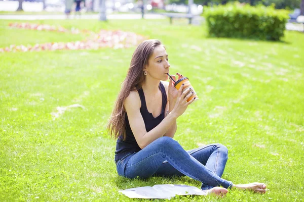 Młoda piękna kobieta siedzi w parku lato — Zdjęcie stockowe