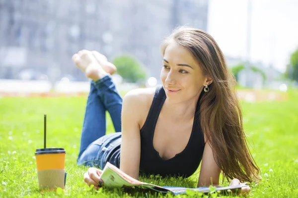 Yaz parkta oturan genç güzel kadın — Stok fotoğraf
