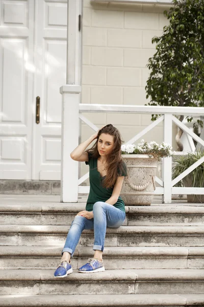 Jeune belle femme aux cheveux bruns en jeans bleu — Photo