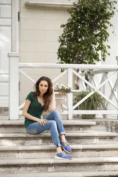 Jeune belle femme aux cheveux bruns en jeans bleu — Photo