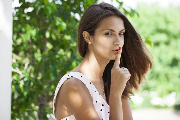 Jovem bela mulher morena colocou o dedo indicador nos lábios como sig — Fotografia de Stock