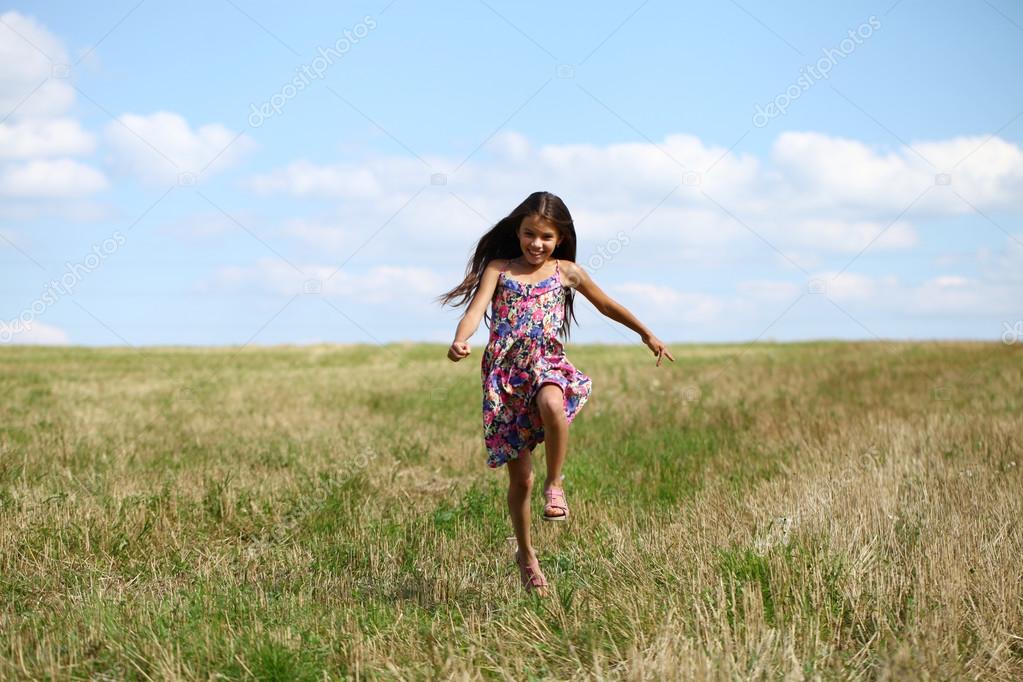 Beautiful young little girl running summer field — Stock Photo © arkusha 119726062