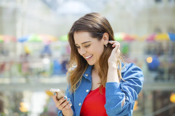 Jonge brunette vrouw bellen via de telefoon in de winkel — Stockfoto