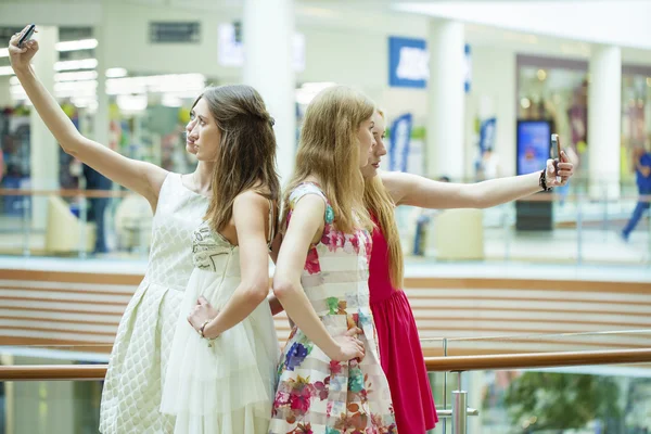 Hermosas y sonrientes mujeres toman una foto de sí misma con un inteligente — Foto de Stock