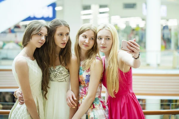 Hermosas y sonrientes mujeres toman una foto de sí misma con un inteligente — Foto de Stock