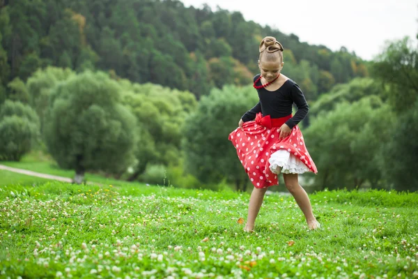 Liten flicka i en vacker klänning som dansar — Stockfoto