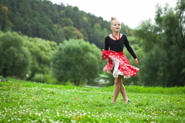 Liten flicka i en vacker klänning som dansar — Stockfoto