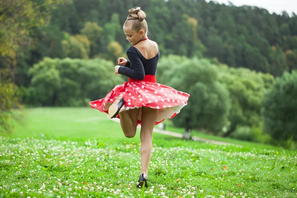 Маленькая девочка в красивом платье танцует — стоковое фото