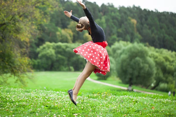 Klein meisje in een mooie jurk dansen — Stockfoto