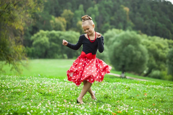 Kleines Mädchen in einem schönen Kleid tanzt — Stockfoto