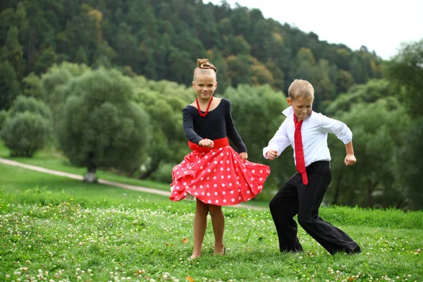 Kleines Mädchen in einem schönen Kleid tanzt — Stockfoto