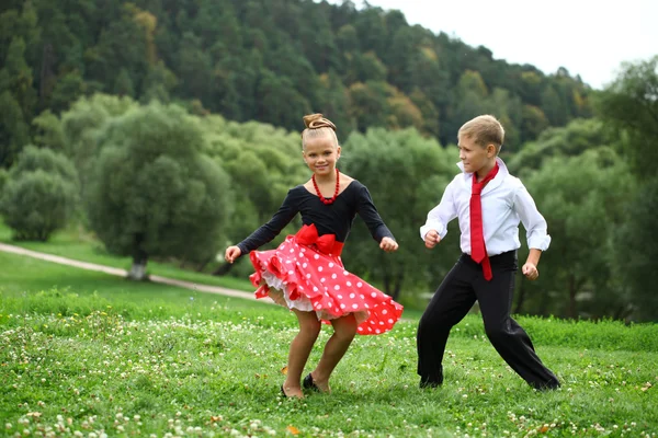 Klein meisje in een mooie jurk dansen — Stockfoto