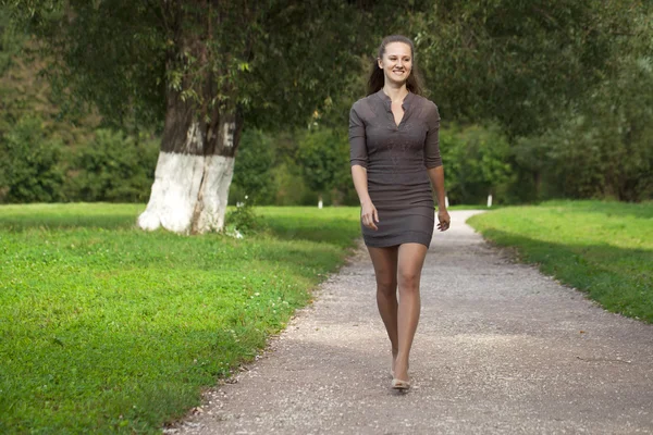 Junge schöne Frau in braunem Kleid spaziert im Sommerpark — Stockfoto