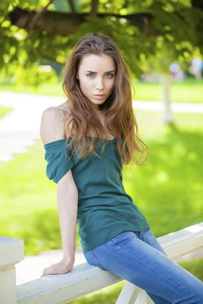 Joven hermosa mujer de pelo castaño en vaqueros azules — Foto de Stock