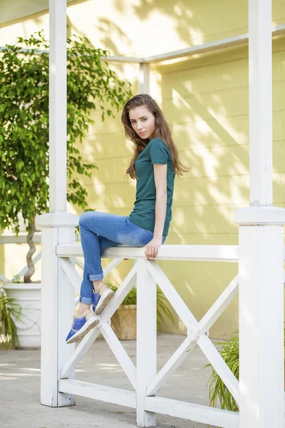 Junge schöne braunhaarige Frau in blauen Jeans — Stockfoto