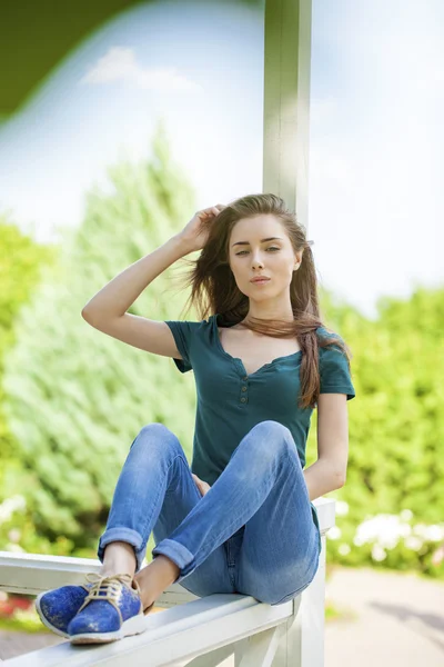 Молода красива коричнева волохата жінка в блакитних джинсах — стокове фото