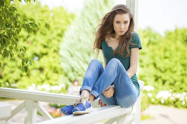 Unga vackra brown haired kvinna i blå jeans — Stockfoto