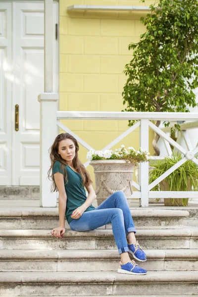 Jeune belle femme aux cheveux bruns en jeans bleu — Photo