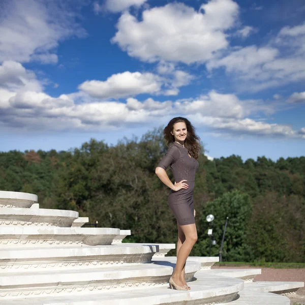 Jovem mulher bonita em vestido marrom caminha no parque de verão — Fotografia de Stock