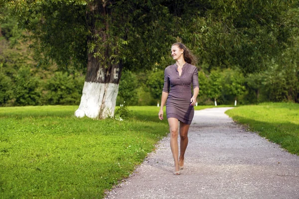 Joven hermosa mujer en vestido marrón camina en el parque de verano —  Fotos de Stock