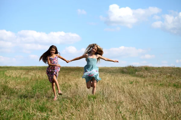 Duas meninas correndo no campo de verão — Fotografia de Stock