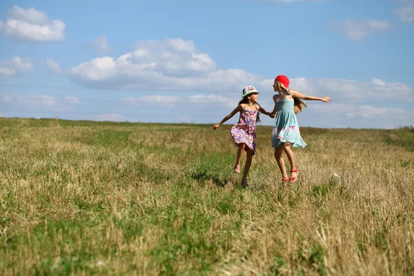 Duas meninas correndo no campo de verão — Fotografia de Stock