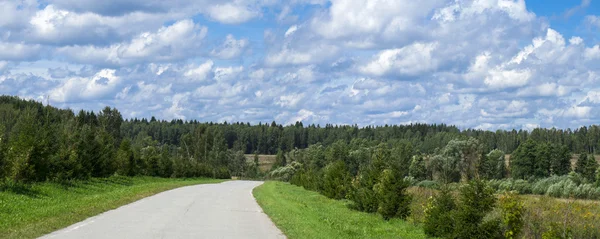 Asphalt road through the green forest and clouds on blue sky — Stock Photo, Image