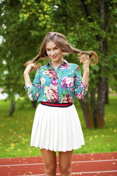 Jonge brunette vrouw in witte rok — Stockfoto