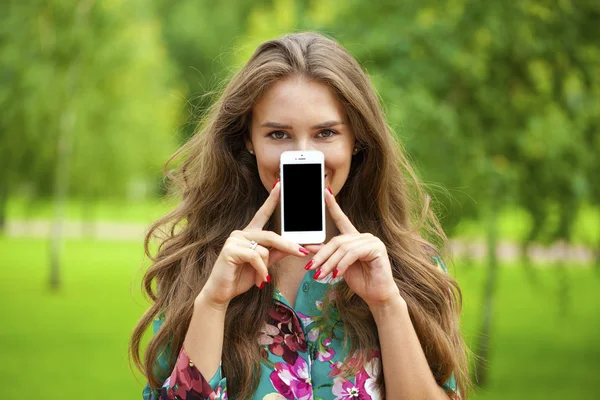 Jovem menina bonita mostrando sua tela do smartphone — Fotografia de Stock