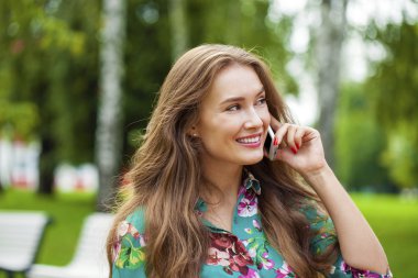 Güzel koyu saçlı genç kadın cep telefonunuza konuşan portresi