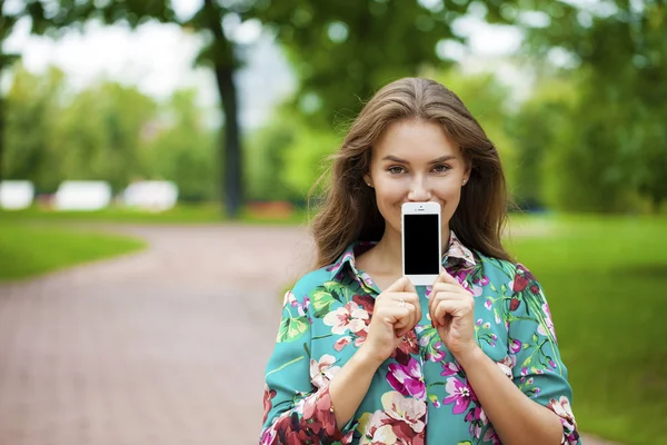 Jovem menina bonita mostrando sua tela do smartphone — Fotografia de Stock