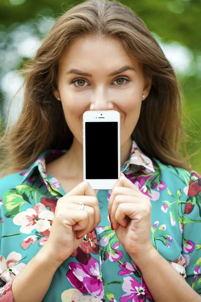 Joven hermosa chica mostrando la pantalla de su teléfono inteligente — Foto de Stock