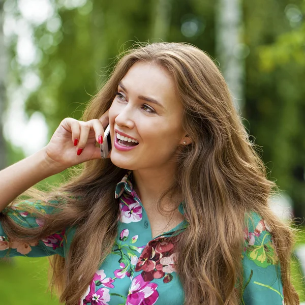 Portret van mooie donkere donkerharige jonge vrouw die spreken op mobiele telefoon — Stockfoto