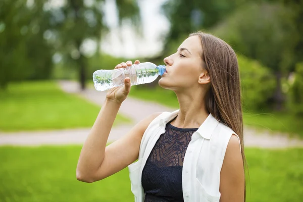 Portrait of young beautiful dark haired woman drinking water — Stock Photo, Image