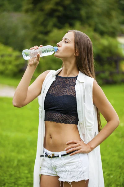 Retrato de una joven hermosa mujer morena bebiendo agua — Foto de Stock