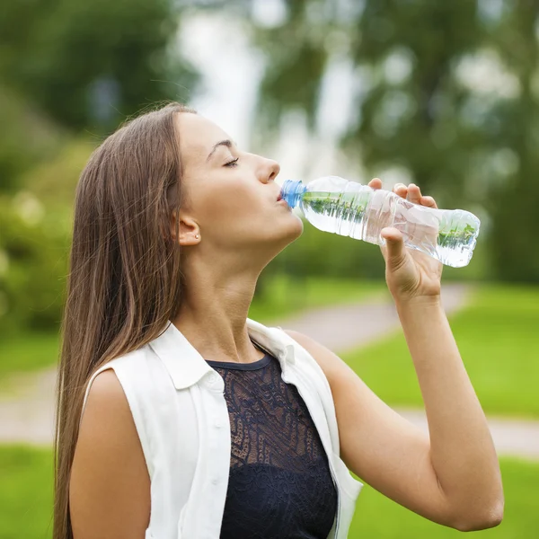 Portret van jonge mooie donkere harige vrouw drinkwater — Stockfoto