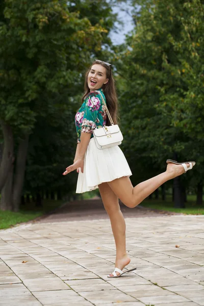 Jonge brunette vrouw in witte rok — Stockfoto