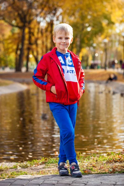 Portret Małego Chłopca Czerwonym Dresie Pozującego Tle Jesiennego Parku — Zdjęcie stockowe