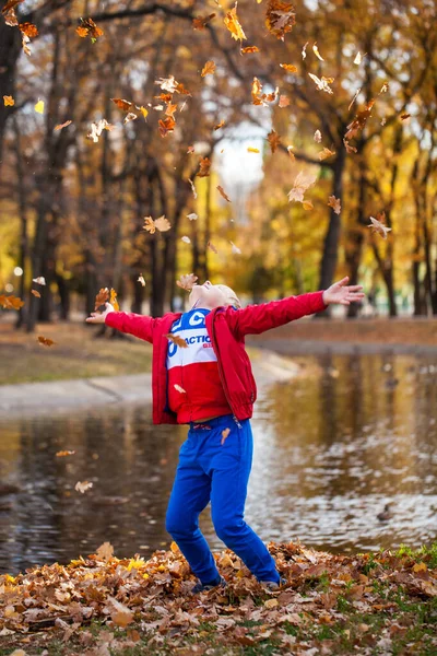 Portré Egy Kisfiúról Piros Melegítőben Pózol Egy Őszi Park Hátterében — Stock Fotó