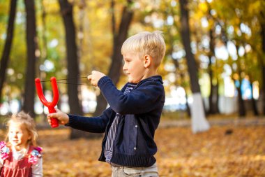 Sonbahar parkında küçük bir çocuğun portresi.