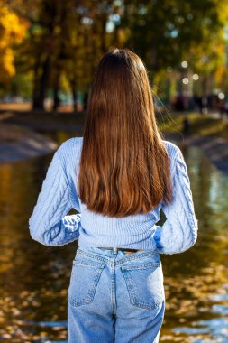 Bir sonbahar parkının arka planında uzun, güzel kadın saçı.