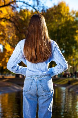 Bir sonbahar parkının arka planında uzun, güzel kadın saçı.