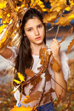 Meşe yapraklı genç bir kızın sonbahar portresi