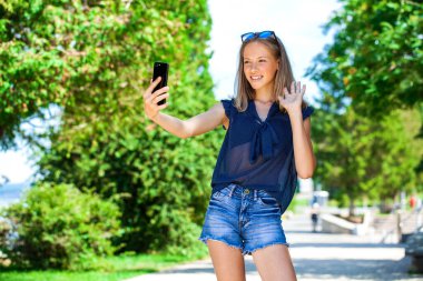 Yaz parkında genç ve güzel sarışın bir kadının portresi.